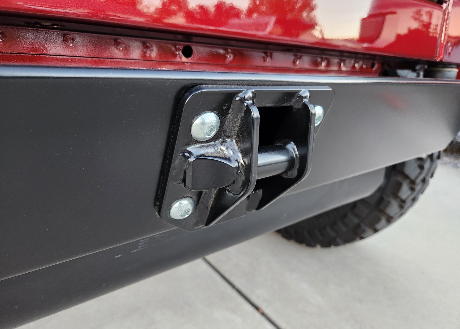 Close-up of a vehicle's hitch receiver on a red vehicle